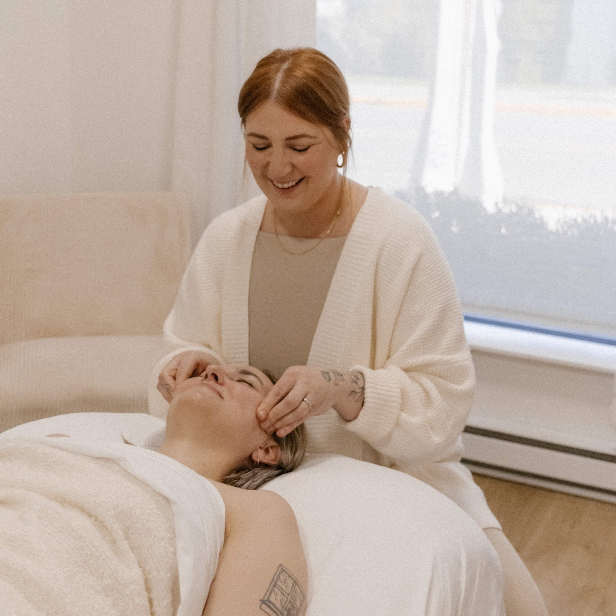 Sasha Ormiston RAc gives patient a face massage as part of a facial rejuvenation acupuncture treatment