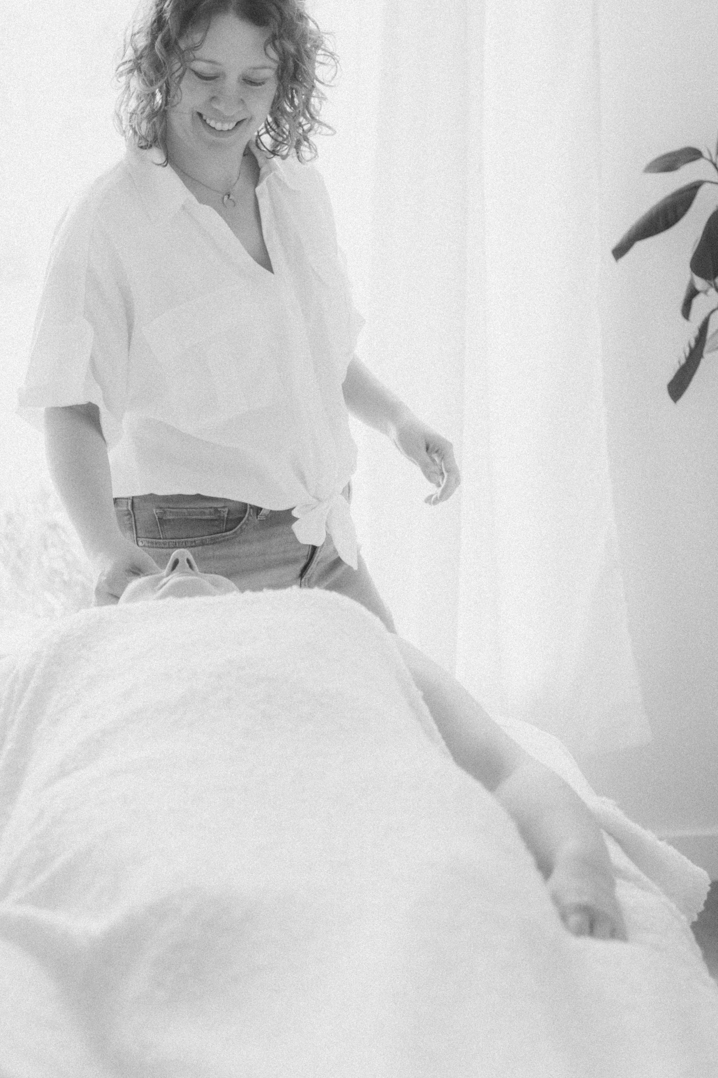 Black and white photo of registered acupuncturist smiling down at client on the table